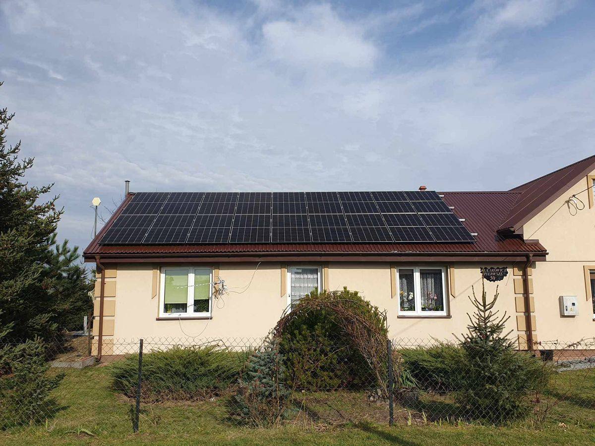 Instalacja fotowoltaiczna na czerwonym dachu parterowego domu